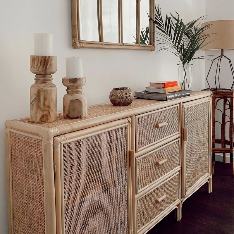 Buffet en rotin dans un salon avec des accessoires dessus